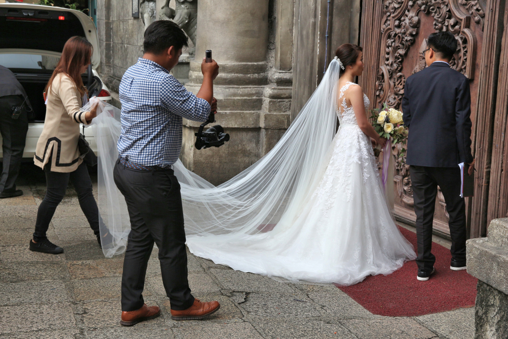 https://www.nuptials.ph/wp-content/uploads/2020/02/Wedding-photographer-takes-photos-of-the-bride-and-groom-entering-church.jpg