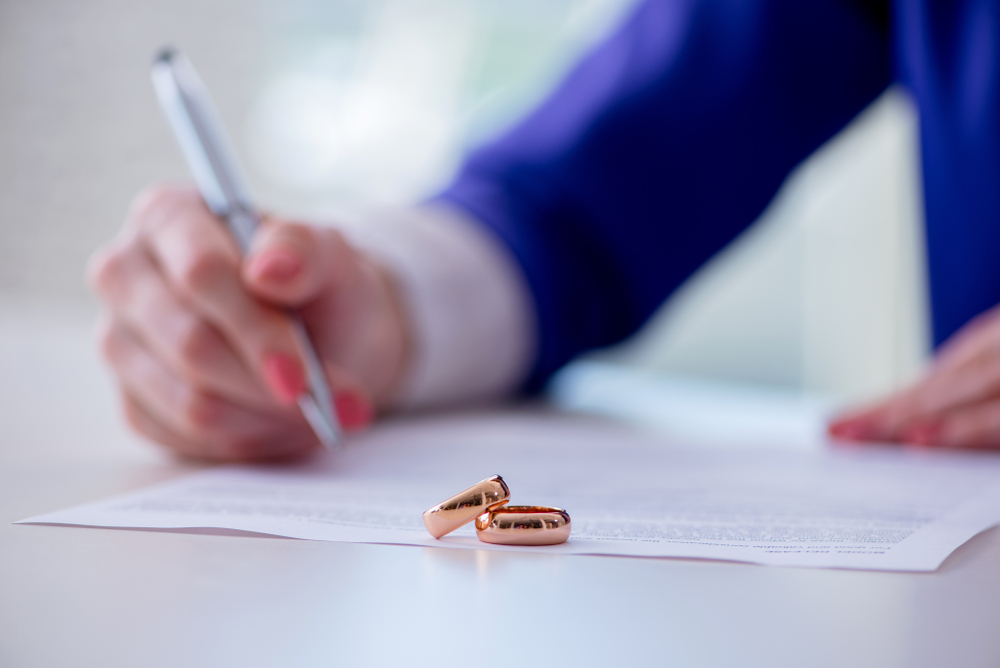 woman signing a prenuptial agreement contract